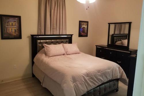 um quarto com uma cama com um espelho e uma cómoda em Villa 1 em Hammond