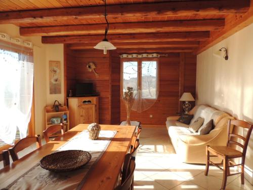 un salon avec une table et un canapé dans l'établissement Gîte Les Sauvasses, à Puy-Sanières