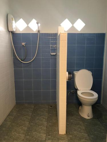 a bathroom with a toilet and a blue tiled wall at ทับศิลารีสอร์ท Tubsila Resort in Chongsadao