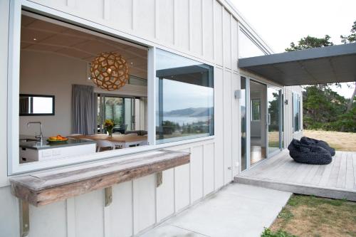a house with a large window on the side of it at Waimarama Heights - Waimarama Holiday Home in Waimarama