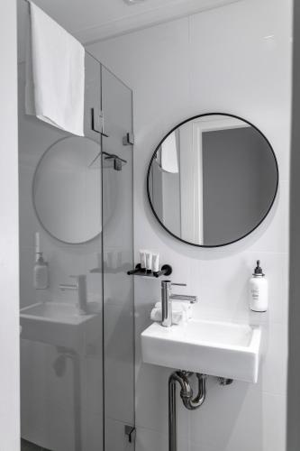a white bathroom with a sink and a mirror at St Marks Randwick in Sydney
