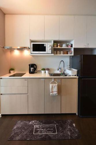 a kitchen with a sink and a microwave at Veranda residence pattaya By Kzy in Jomtien Beach