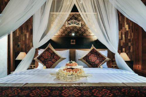 a bedroom with a bed with a canopy at KERAMAN SUITE UBUD in Ubud