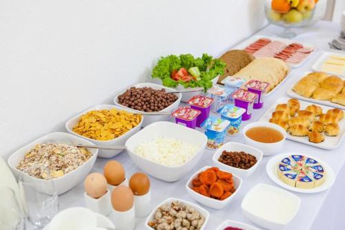 einen Tisch mit Schalen verschiedener Arten von Lebensmitteln in der Unterkunft TourAsia Hotel in Bischkek