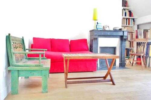 a living room with a red couch and a chair at Very Nice Apartment Between Pigalle And Montmartre in Paris