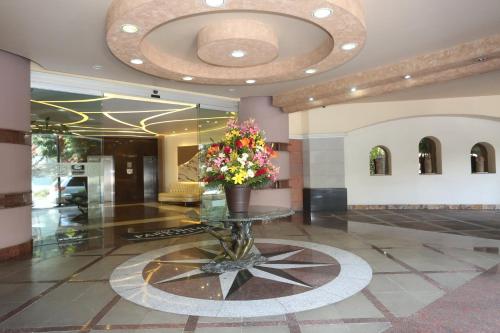 un vestíbulo con una mesa de cristal con un jarrón de flores en Hotel Park Nilo Reforma, en Ciudad de México