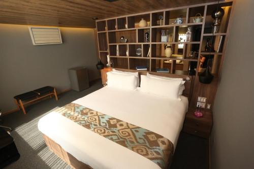 a bedroom with a large bed and a book shelf at Hotel Park Nilo Reforma in Mexico City