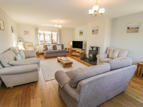 a living room with two couches and a tv at Awel Y Llan in Llanfair