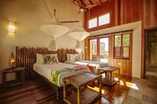 a bedroom with two beds in a room with wooden walls at Jungle Bay Dominica in Soufrière