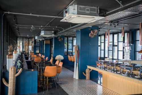 a restaurant with blue walls and orange chairs at Citygate Kamala Resort and Residence - Official Account in Kamala Beach