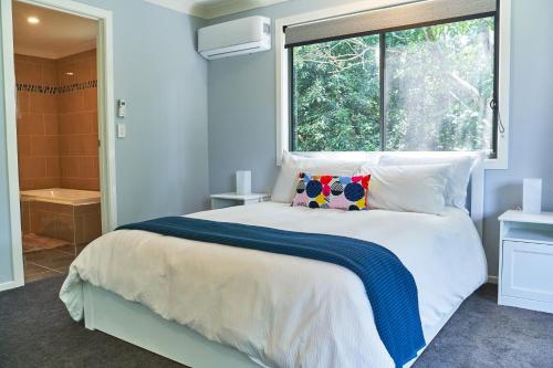 um quarto com uma cama grande e uma janela em Treetops Haven em Maleny