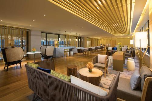 a lobby of a hotel with couches and tables at Holiday Inn Kunshan Huaqiao by IHG in Kunshan