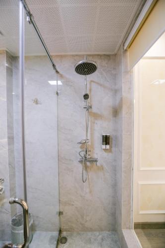 a shower with a glass door in a bathroom at Vincent Halong Hotel in Ha Long