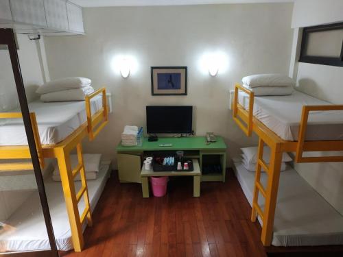 a room with two bunk beds and a desk with a computer at Tsengwen Youth Activity Center in Nanxi