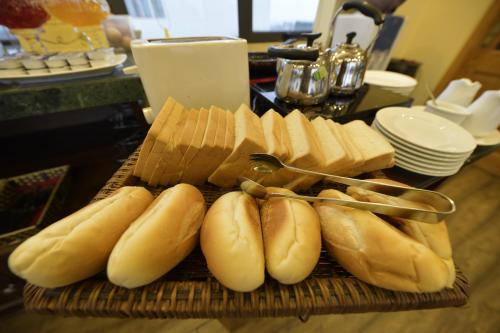 Een stapel hotdogs en kaas op een snijplank. bij Hanoi HM Boutique Hotel in Hanoi