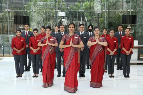 a group of people standing in front of a group of men at Taj City Centre Gurugram in Gurgaon