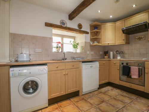 a kitchen with a washing machine and a dishwasher at Springarth Cottage in Morland
