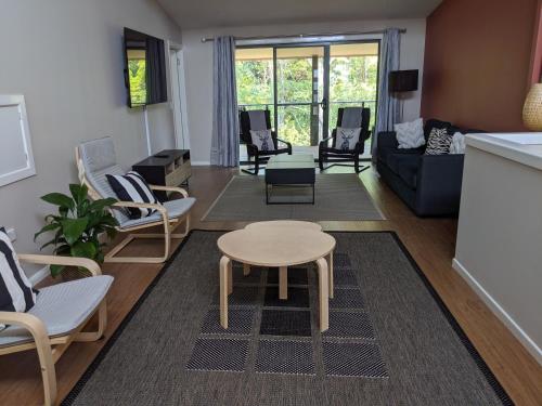 a living room with chairs and a table at Treetops Haven in Maleny