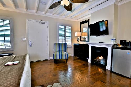 a living room with a fireplace and a tv at Beach Bungalow Inn and Suites in Morro Bay