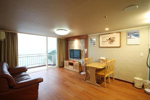 a living room with a table and a television at Kumgangsan Condo Sokcho in Goseong