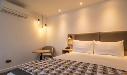 a hotel room with a bed and a table at Holiday Inn - Leicester - Wigston by IHG in Leicester