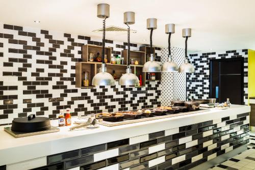 a kitchen with black and white tiles on the wall at Holiday Inn London Watford Junction by IHG in Watford
