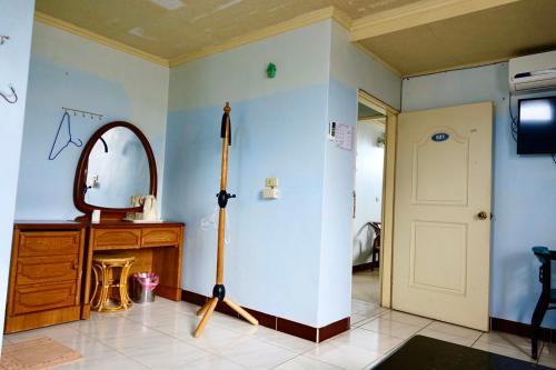ein Zimmer mit einem Spiegel und einem Schwert in der Unterkunft Yi Mei Hotel in Jinshan