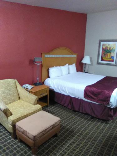 a hotel room with a bed and a chair at Nation's Inn Kinston in Kinston