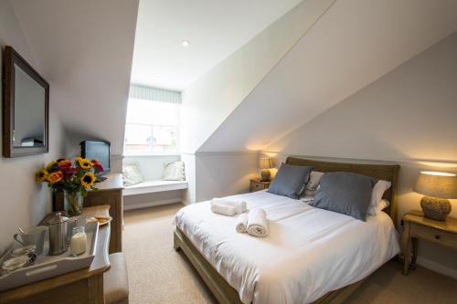 a bedroom with a large white bed and a window at The Fox Inn in Ansty
