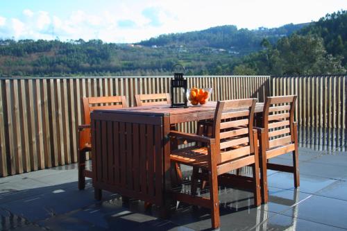 a wooden table with chairs and a bottle and a pumpkin on it at Dantas Village in Moure
