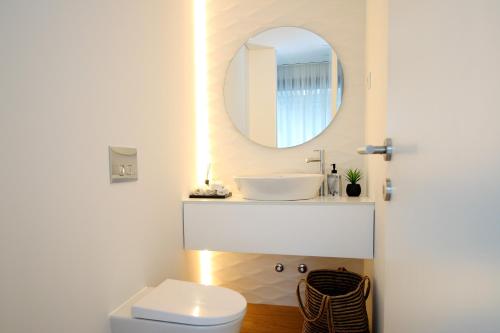 ein Badezimmer mit Waschbecken und Spiegel in der Unterkunft Dantas Village in Moure