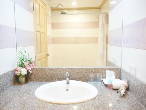 a bathroom counter with a sink and a mirror at Bay Hotel Srinakarin in Bangna