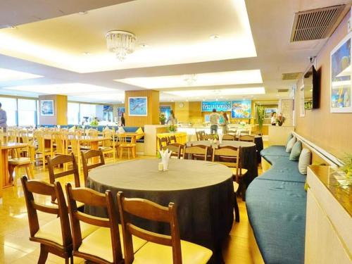 a dining room with tables and chairs and a restaurant at Bay Hotel Srinakarin in Bangna