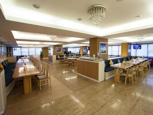 a restaurant with tables and chairs and a bar at Bay Hotel Srinakarin in Bangna