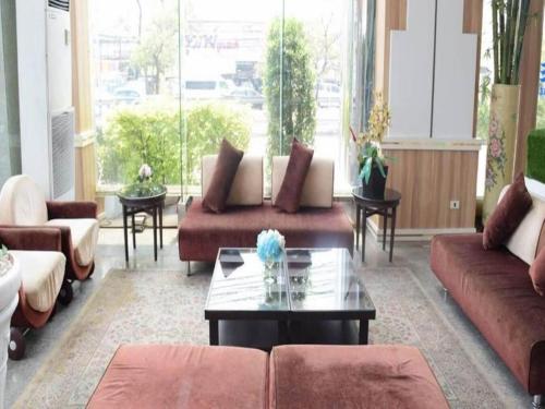 a living room with couches and a coffee table at Bay Hotel Srinakarin in Bangna