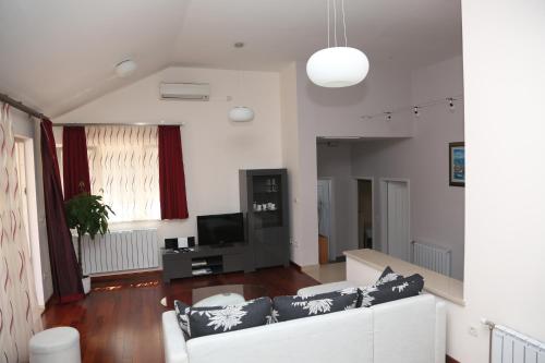 a living room with a white couch and a tv at Apartment Markorcula in Korčula