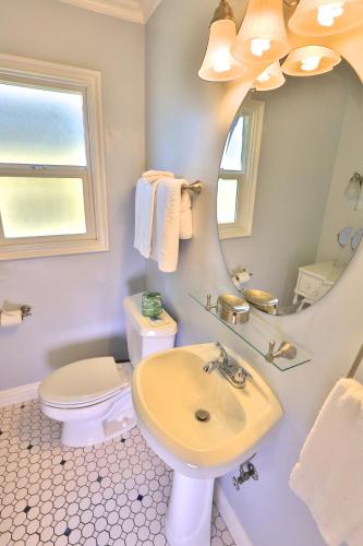 a bathroom with a sink and a toilet and a mirror at Beach Bungalow Inn and Suites in Morro Bay