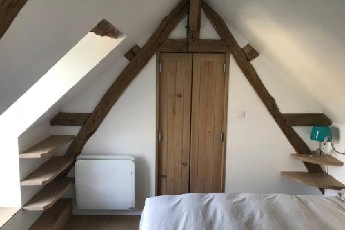 une chambre avec une porte en bois dans un grenier dans l'établissement Charmante maison rénovée en Pays de la Loire ., à Durtal