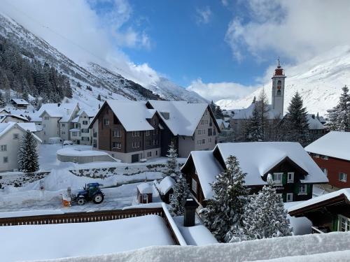 a village covered in snow with a church at Alpenhotel Schlüssel in Andermatt
