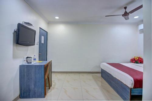 a hotel room with a bed and a tv at Hotel Sunshine Airport in Mumbai