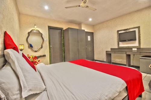 a bedroom with a red and white bed and a television at Hotel Sunshine Airport in Mumbai