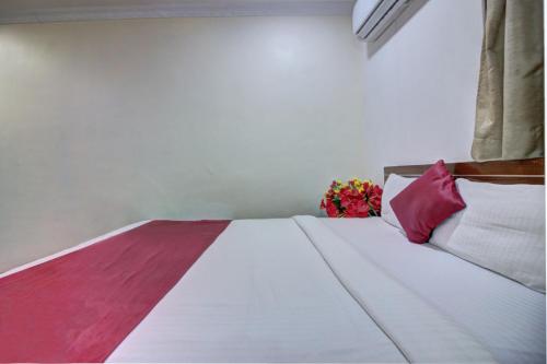 a bedroom with a bed with a vase of flowers at Hotel Sunshine Airport in Mumbai