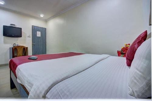 a bedroom with a large bed with a tv on the wall at Hotel Sunshine Airport in Mumbai
