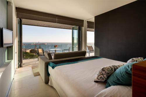 a bedroom with a large bed with a view of the ocean at Parador de Cádiz in Cádiz