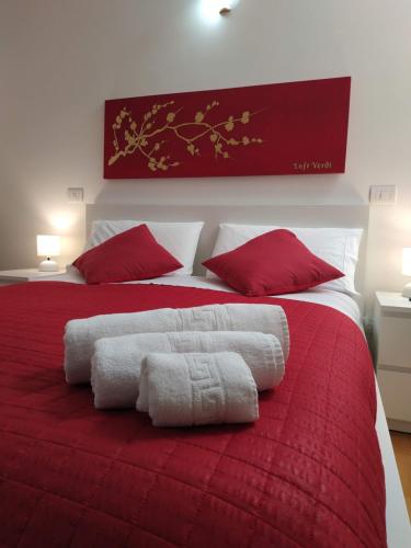 una camera con letto rosso e bianco con cuscini rossi di Loft VERDI Holiday Viterbo a Viterbo