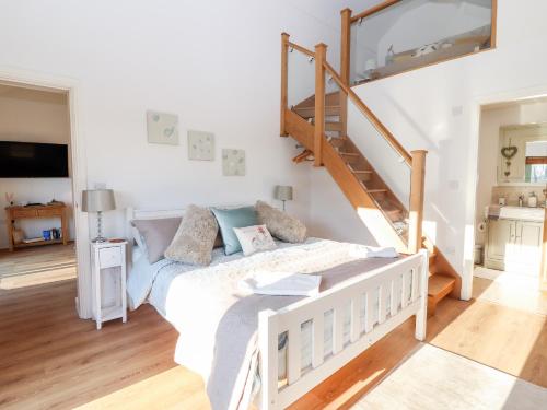 a bedroom with a bed and a staircase at Well View Cottage in Tarporley