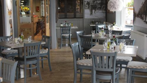 uma sala de jantar com mesas e cadeiras num restaurante em The Lion Waddesdon em Waddesdon