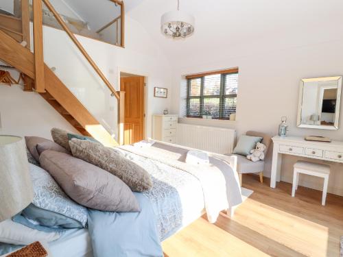 1 dormitorio con 1 cama grande y una escalera en Well View Cottage, en Tarporley