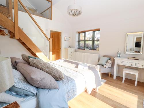 a bedroom with a large bed and a staircase at Well View Cottage in Tarporley