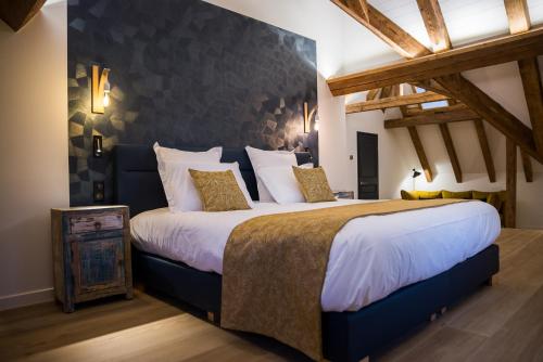 ein Schlafzimmer mit einem großen Bett in einem Zimmer in der Unterkunft Maison d'Hôtes Les Jardins de Madeleine in Bernardvillé